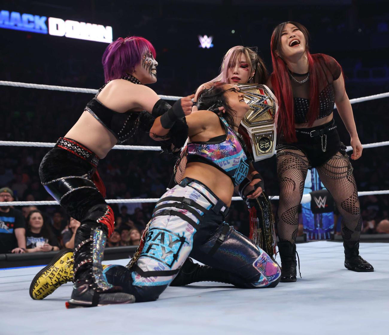 ベイリー（中央手前）を抑え込むアスカ（左端）カイリ・セイン（中央奥）、イヨ・スカイ（C）WWE
