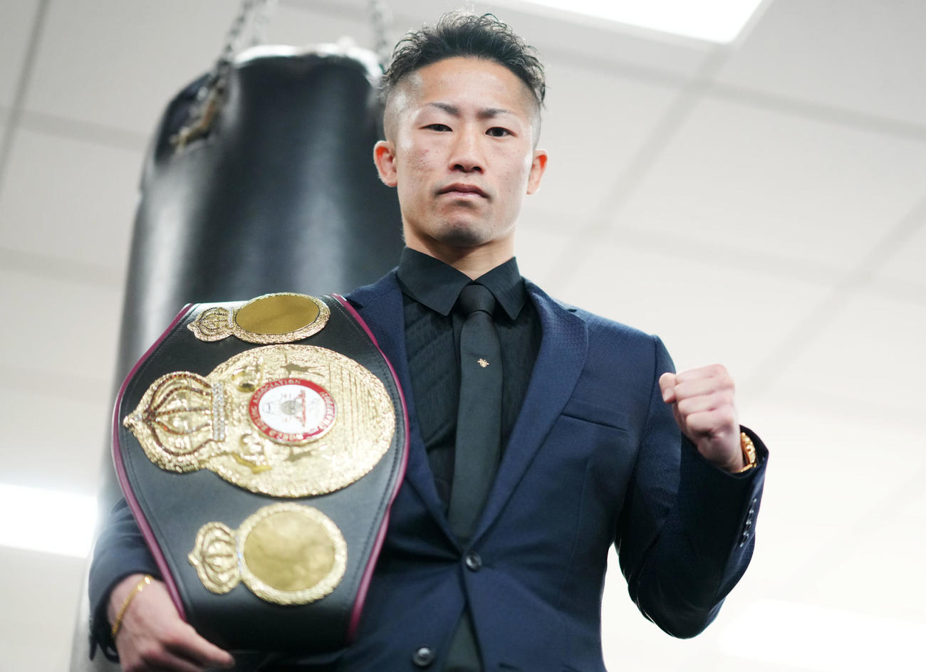 ベルトを肩にかけてポーズを決める井上拓（撮影・横山健太）