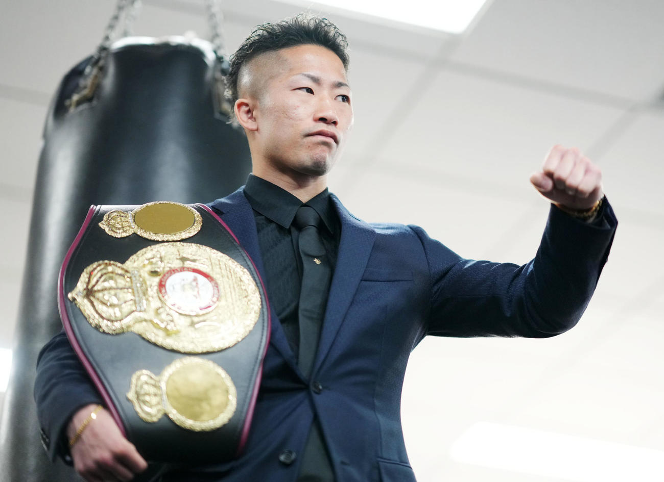 ベルトを肩にかけてポーズを決める井上拓（撮影・横山健太）