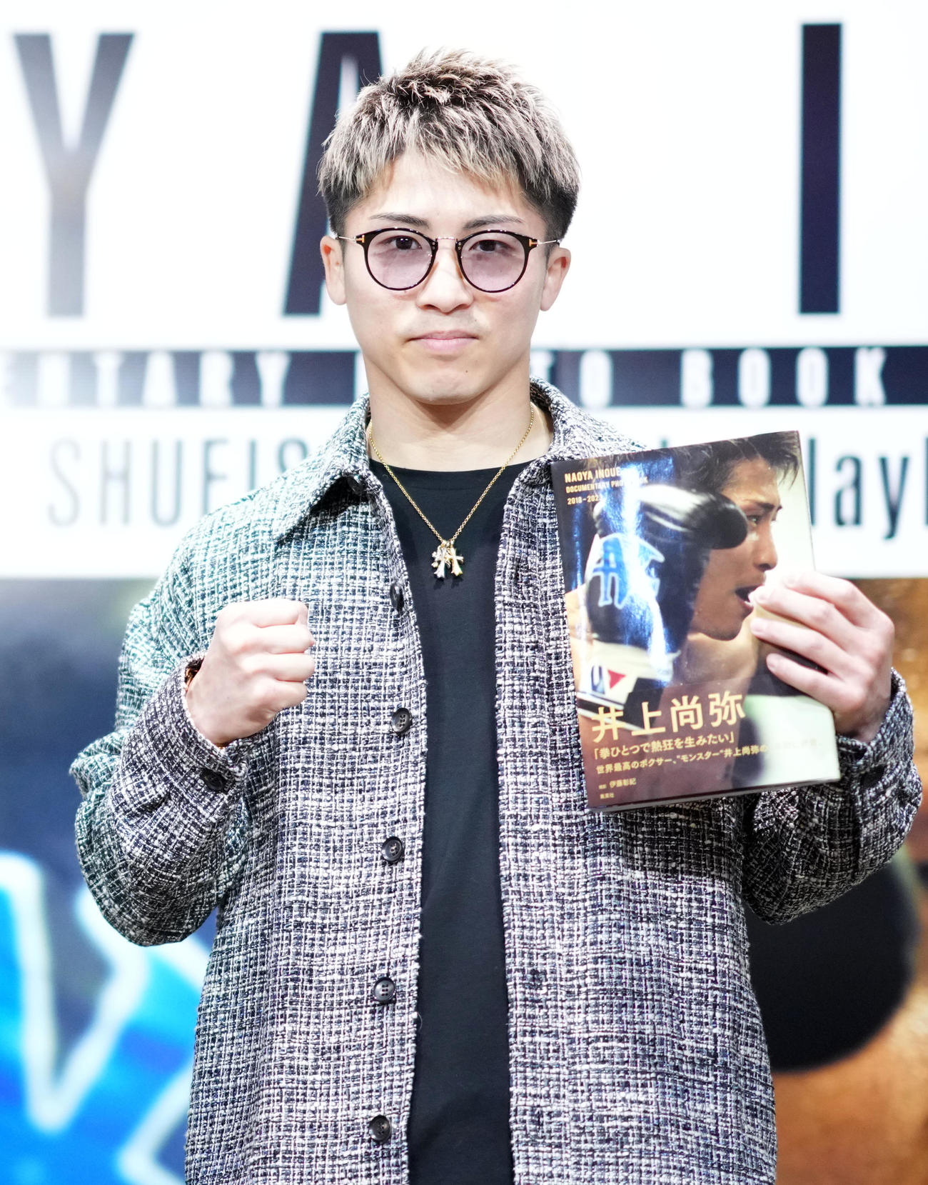 写真集を手にポーズを決める井上尚（撮影・横山健太）