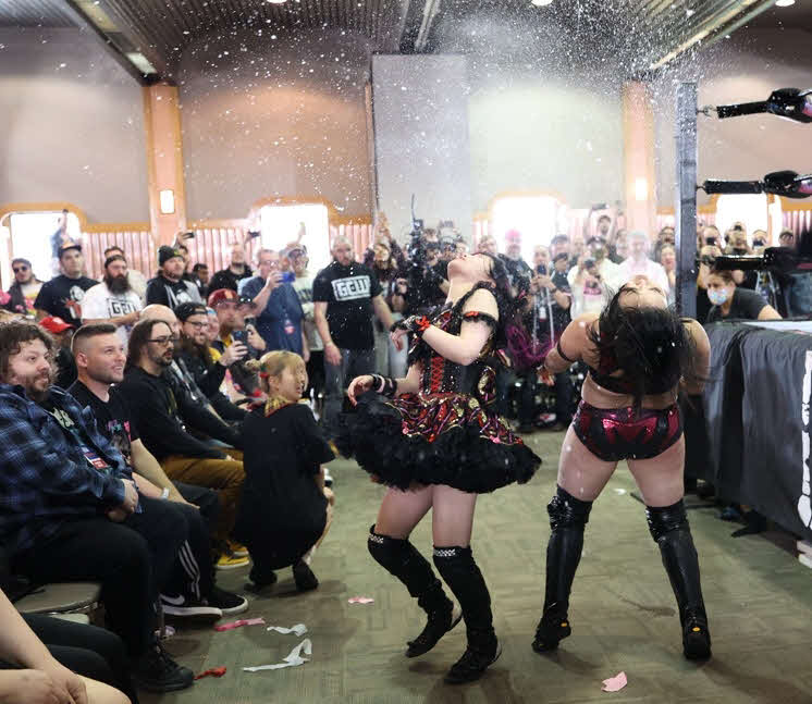 東京女子プロレス　攻撃を受け、口に含んだビールを吹き出してしまう、山下実優（右）、伊藤麻希（東京女子プロレス提供）