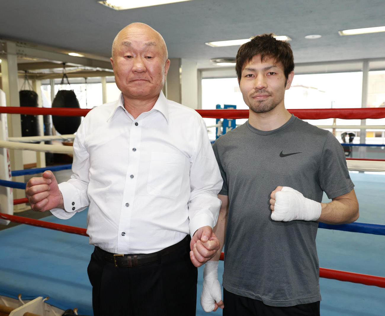 倉敷守安ジム守安竜也会長（左）とファイティングポーズをするWBA世界フライ級王者のユーリ阿久井（撮影・中島郁夫）