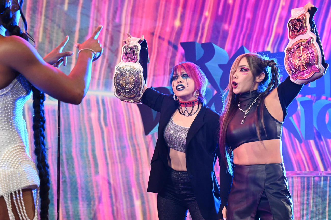 ビアンカ・ブレア、ジェイド・カーギルと向き合い、WWE女子タッグベルトを掲げた王者アスカ（左）とカイリ・セイン（C）WWE
