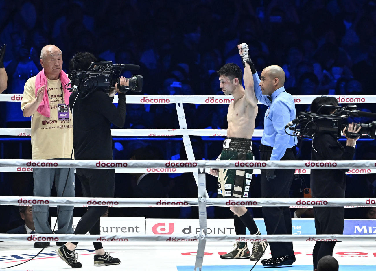 判定勝ちし勝ち名乗りを受けるユーリ阿久井。左は守安会長（撮影・滝沢徹郎）