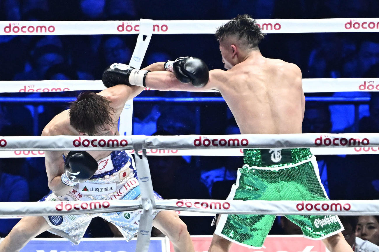 8回、パンチを交錯させる石田（左）と井上拓（撮影・滝沢徹郎）