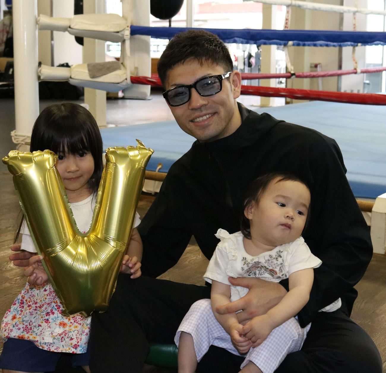 初防衛から一夜明け、子どもと笑顔で写真に納まるユーリ阿久井（中央）。左は長女の千聖ちゃん、右は次女の琴乃ちゃん（撮影・水谷京裕）