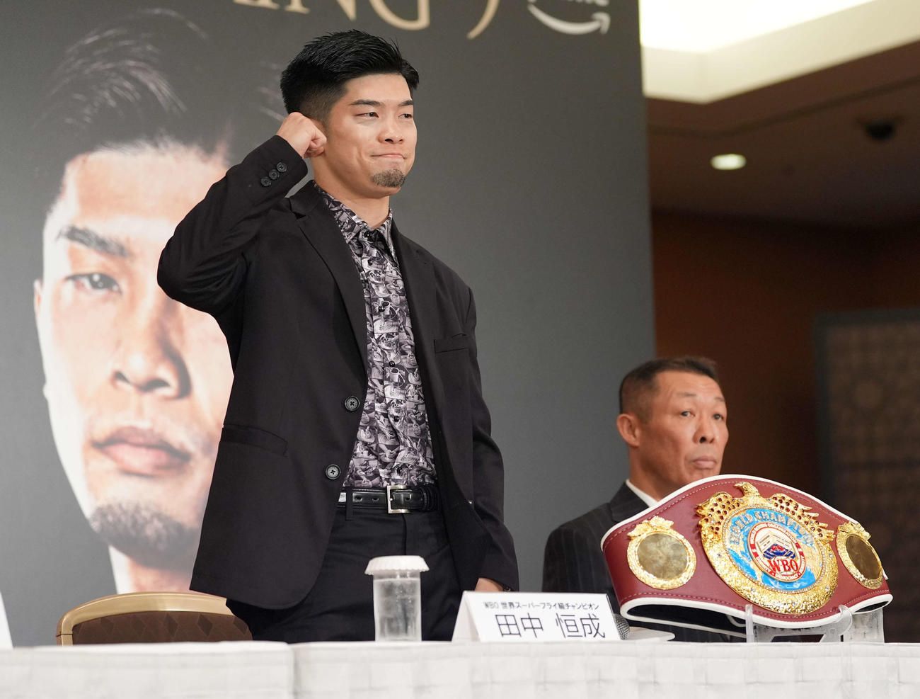 記者会見でガッツポーズのWBO世界スーパーフライ級チャンピオン田中（撮影・井上学）