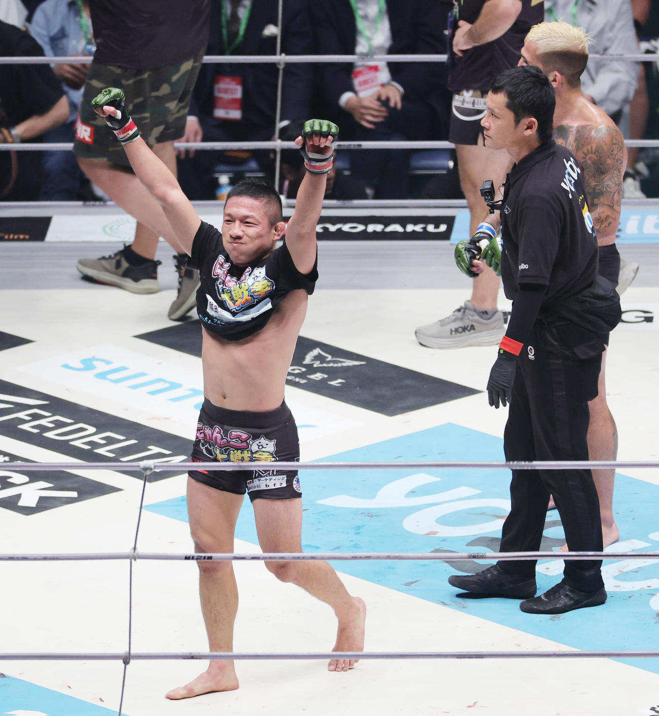 試合を終え、勝利を確信し喜ぶ堀口恭司。後方はセルジオ・ペティス（撮影・野上伸悟）
