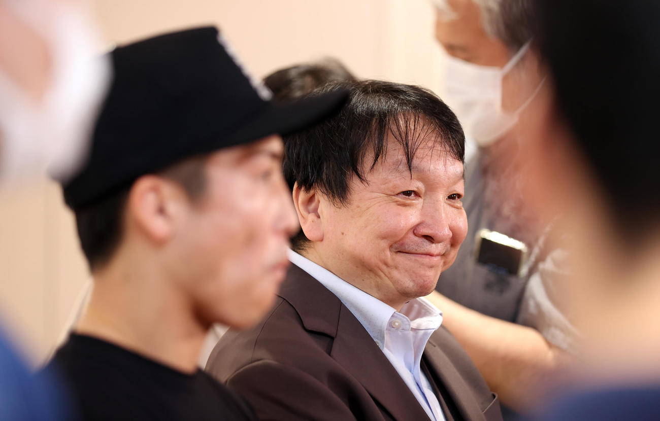 米国から帰国し、報道陣の取材を受け、笑顔を見せる大橋会長（右奥）。左手前は井上（撮影・大野祥一）