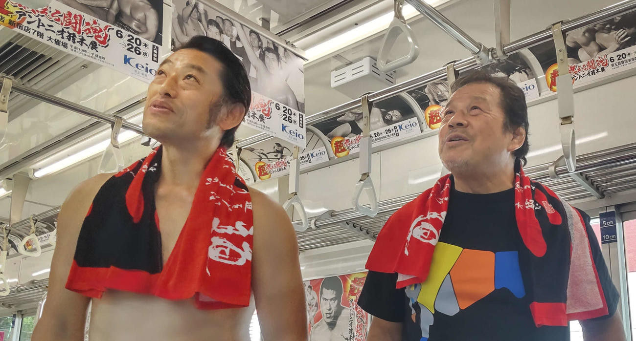 超・猪木展の広告で埋めつくされた「闘魂トレイン」を興味深く見る藤波辰爾（右）とアントキの猪木