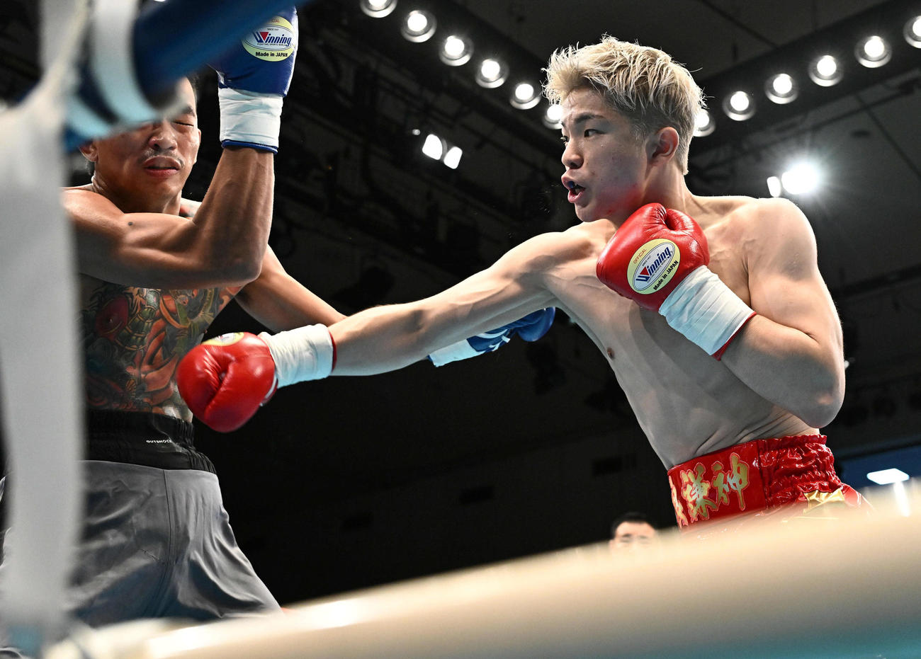 1回、由良（右）はマナチャイ・ピアスイにパンチを打ち込む（撮影・滝沢徹郎）