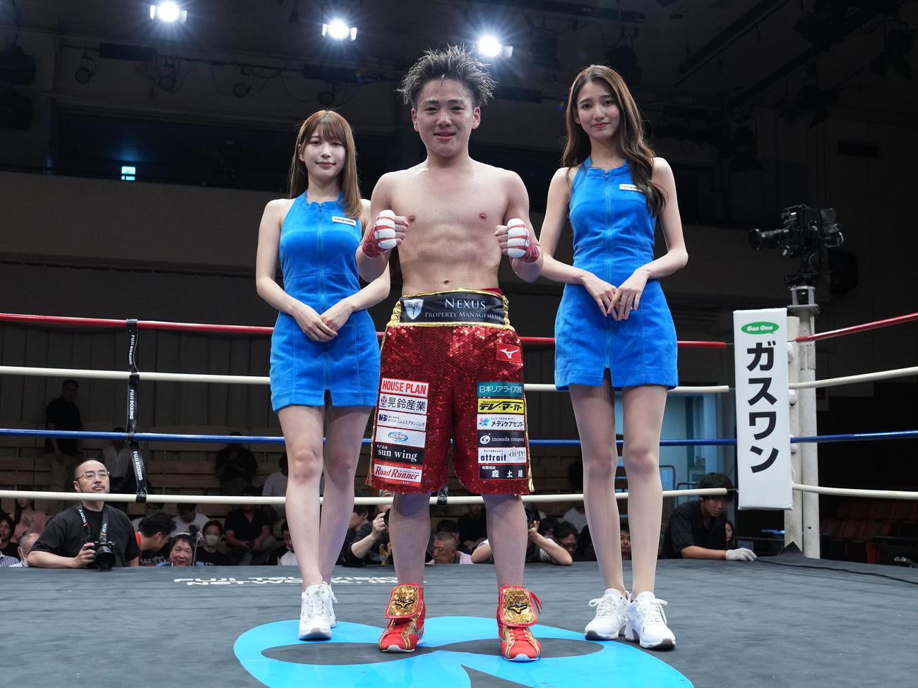 TKO勝ちを収めラウンドガールと記念撮影する森（撮影・小沢裕）