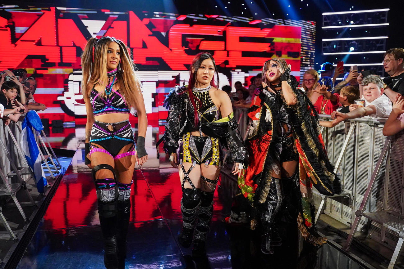 6人タッグマッチに向け、入場するダコタ・カイ（左端）、イヨ・スカイ（中央）、カイリ・セイン（C）WWE
