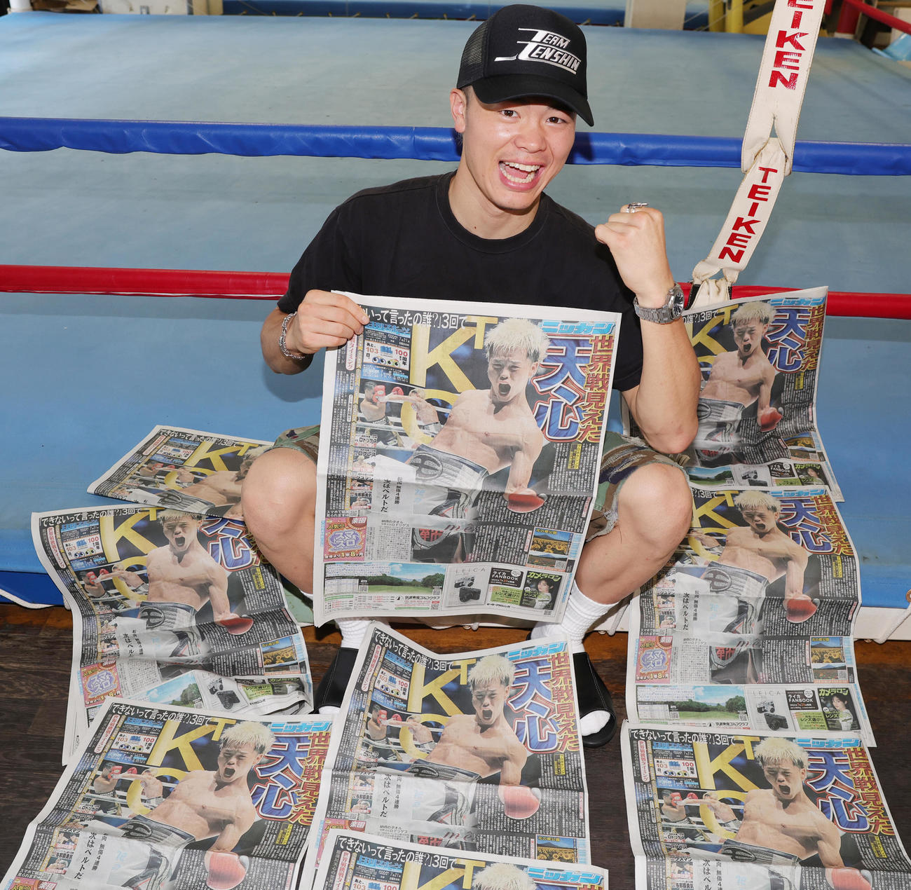 試合から一夜明け、一面で報じる日刊スポーツを手にガッツポーズの那須川天心（撮影・野上伸悟）