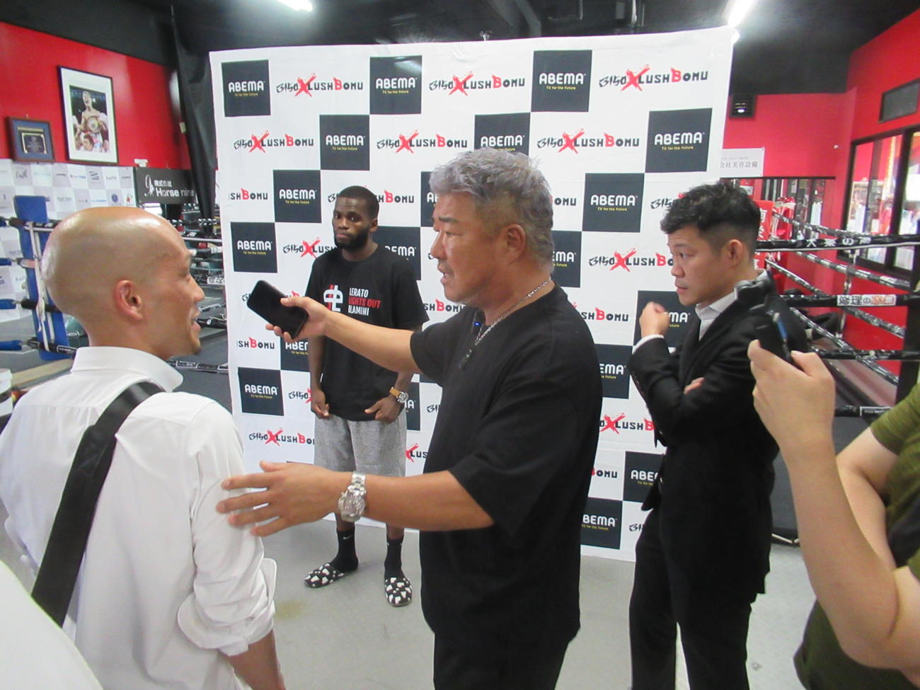 通訳（左）を介しドラミニ（左から2人目）に詰め寄る史郎氏（同3人目）。右はプロモーターの興毅氏（撮影・実藤健一）
