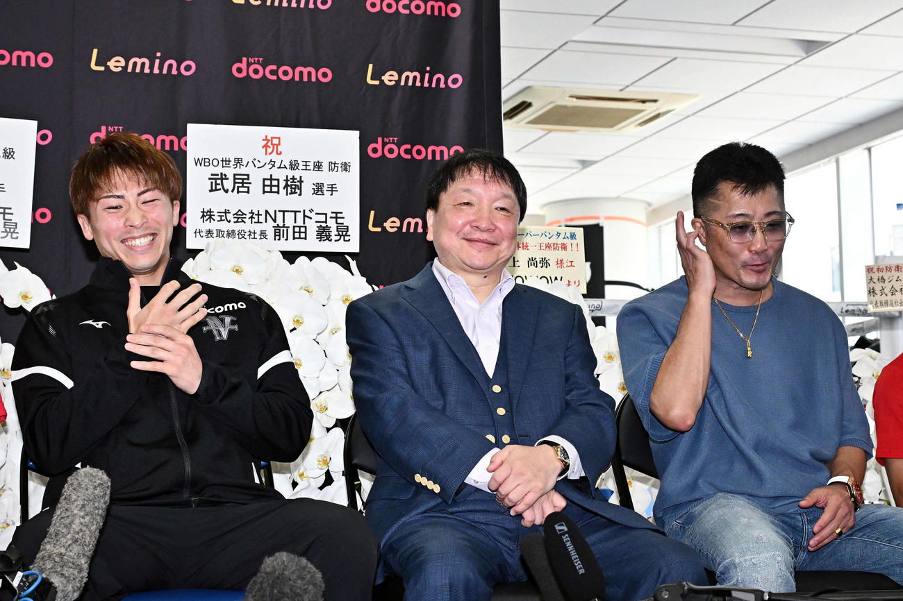 一夜明け会見で笑顔をみせる井上（左）、大橋会長（中央）、父の真吾トレーナー（撮影・滝沢徹郎）　