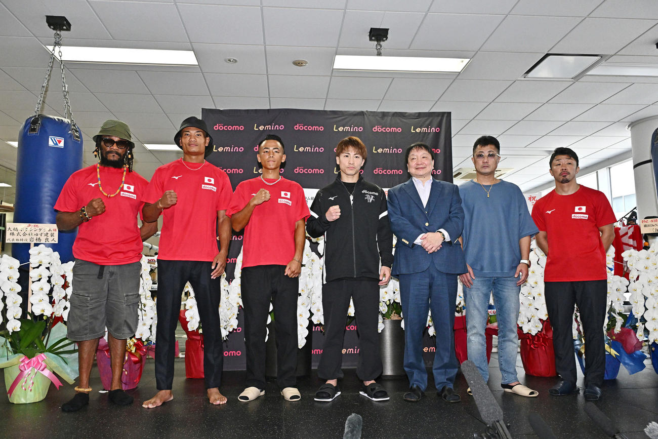 一夜明け会見で記念撮影する井上（中央）ら。左からジャスティス・コジョトレーナー、平岡、武居、1人目おいて大橋会長、真吾トレーナー、八重樫トレーナー（撮影・滝沢徹郎）　