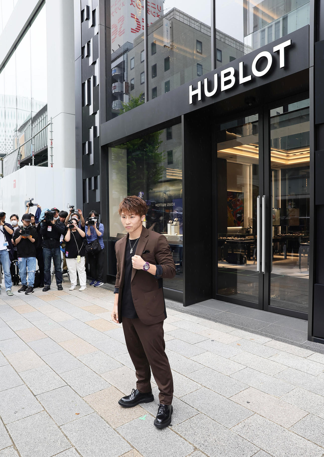 店舗の前でポーズを決める井上尚弥（撮影・足立雅史）