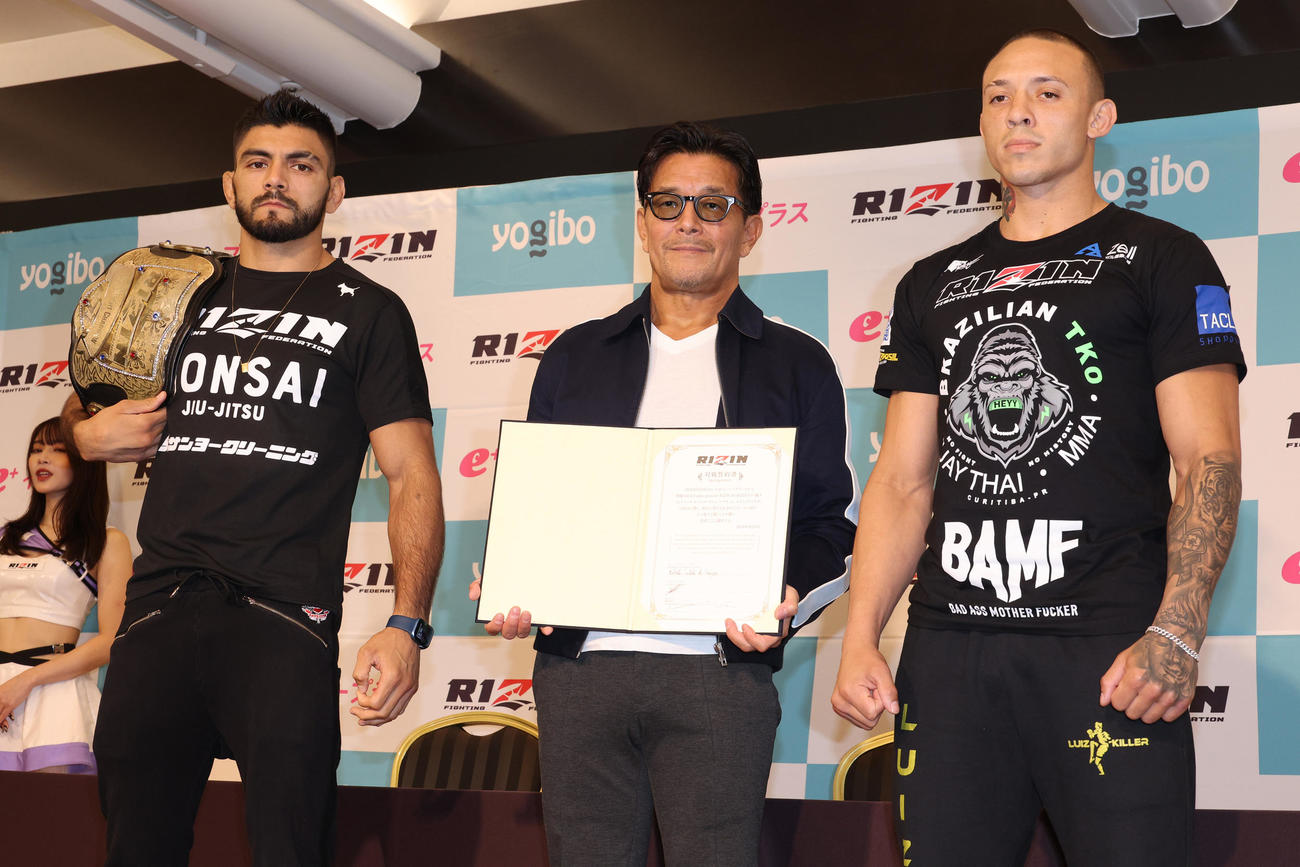 調印を終えたホベルト・サトシ・ソウザ（左）とルイス・グスタボ。中央はRIZIN榊原信行CEO（撮影・中島郁夫）