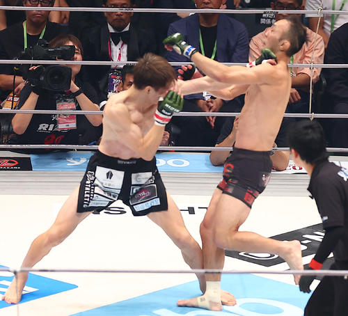 キム・スーチョル（右）に左ストレートを浴びせる井上（撮影・中島郁夫）