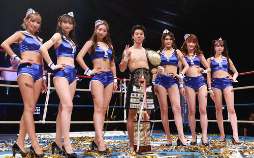 55キロ以下世界最強トーナメントで優勝し、K－1ガールズと記念撮影する金子晃大（撮影・野上伸悟）
