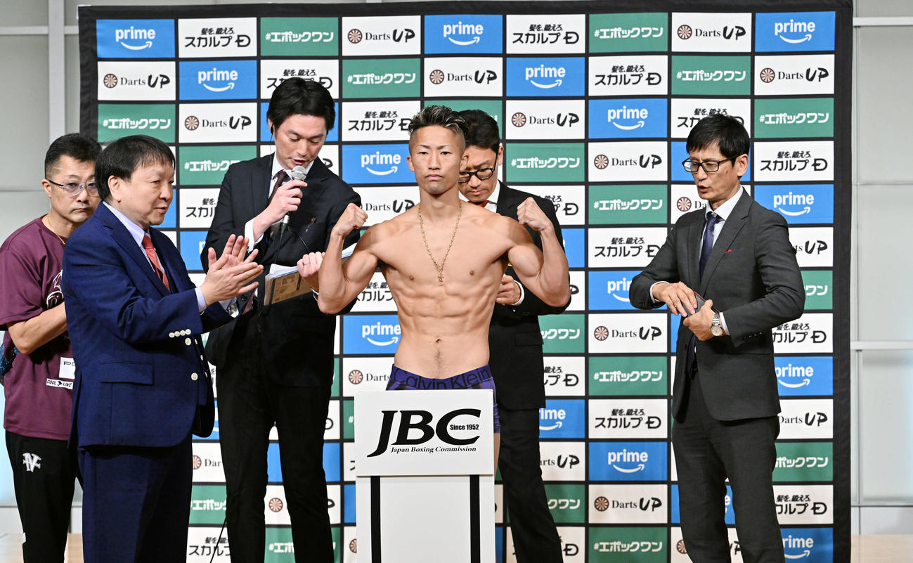 計量をクリアしポーズを決める井上拓。左は父の真吾トレーナー、同2人目は大橋会長（撮影・滝沢徹郎）