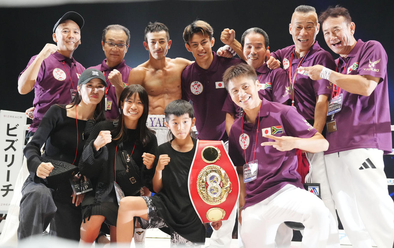 タイトル奪取し記念撮影をする矢吹（後列・左から3人目）同・右は力石（前列・左から）妻・恭子さん、長女・夢月さん、長男・克羽さん（撮影・森本幸一）