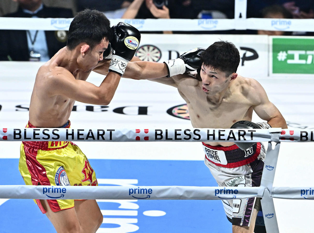 1回、ユーリ阿久井（右）はチャルンパックにパンチを打ち込む（撮影・滝沢徹郎）