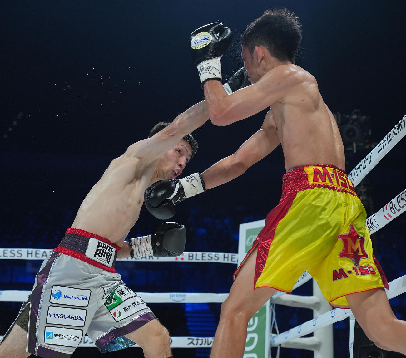 ユーリ阿久井政悟対タナンチャイ・チャルンパック　4回、右ストレートを打ち込むユーリ阿久井（左）（撮影・横山健太）