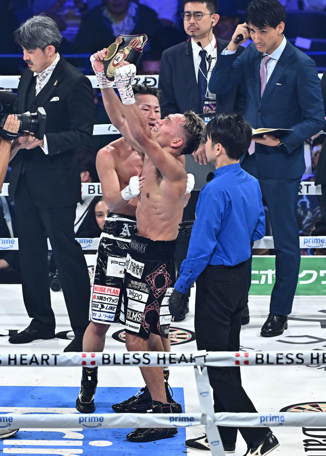 新チャンピオンとなりベルトを掲げる堤（右）は井上拓からたたえられる（撮影・滝沢徹郎）
