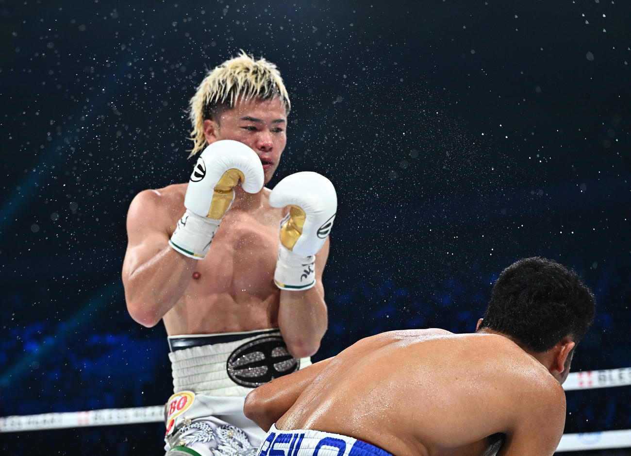 4回、那須川（左）は汗を飛ばしながらアシロを攻める（撮影・滝沢徹郎）