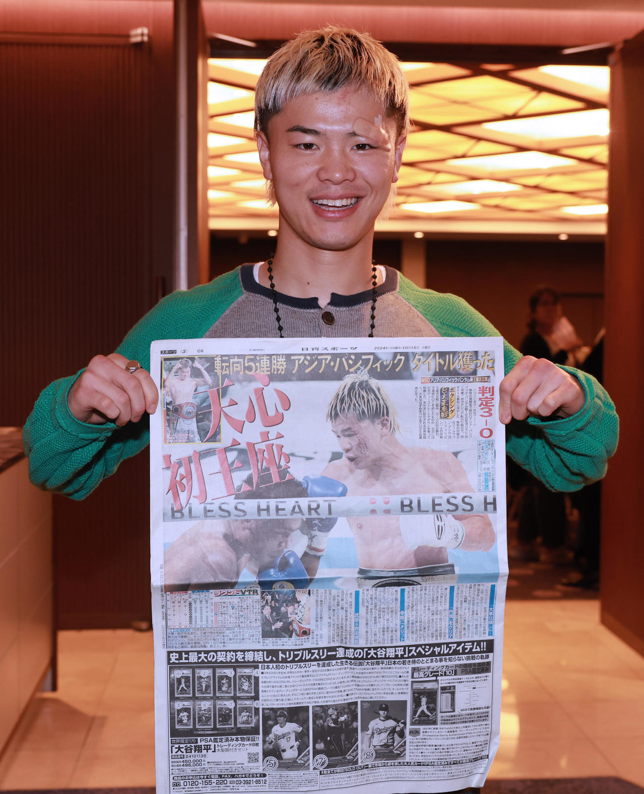 日刊スポーツを手に笑顔を見せるWBOアジア・パシフィック・バンタム級王者の那須川（撮影・野上伸悟）