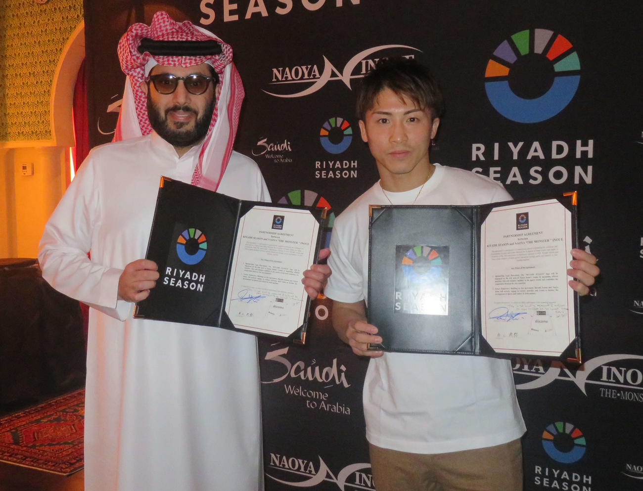 サウジアラビア政府直轄イベント、リヤド・シーズンとのスポンサー契約書に調印した井上尚弥（右）。左はサウジアラビア総合娯楽庁トゥルキ・アラルシク長官