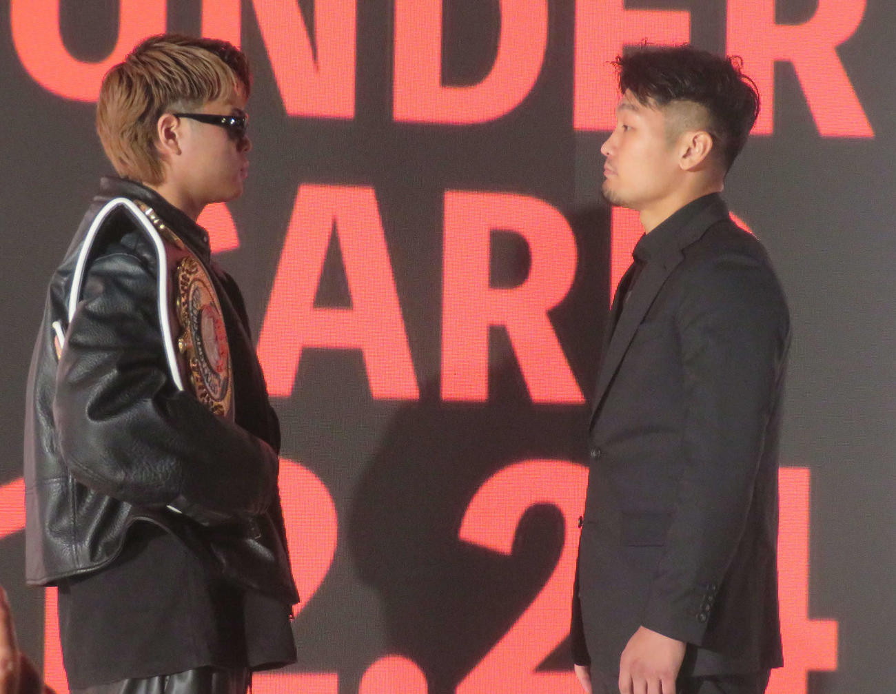 記者会見で、元日本ウエルター級王者坂井祥紀（右）とフェースオフする東洋太平洋、WBOアジア・パシフィック同級王者佐々木尽