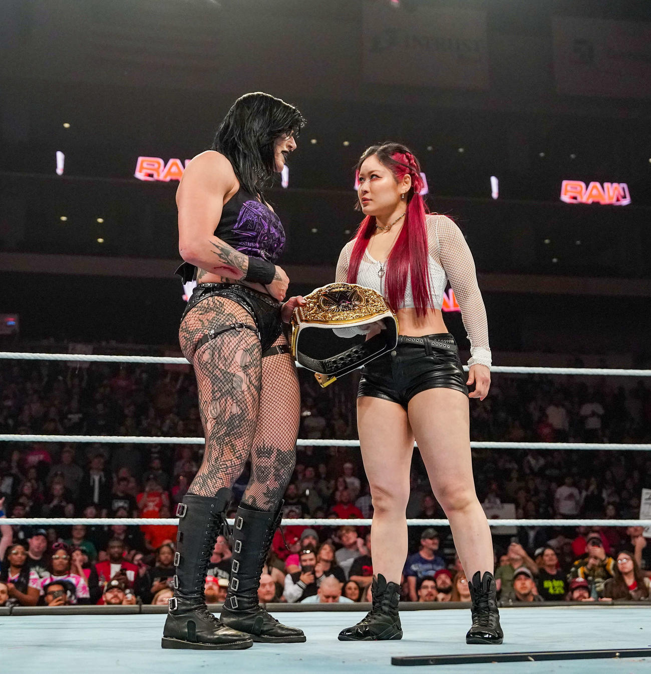 リング上でWWE女子世界王座ベルトを持ってリア・リプリー（左）と視線を合わせたイヨ・スカイ（C）WWE