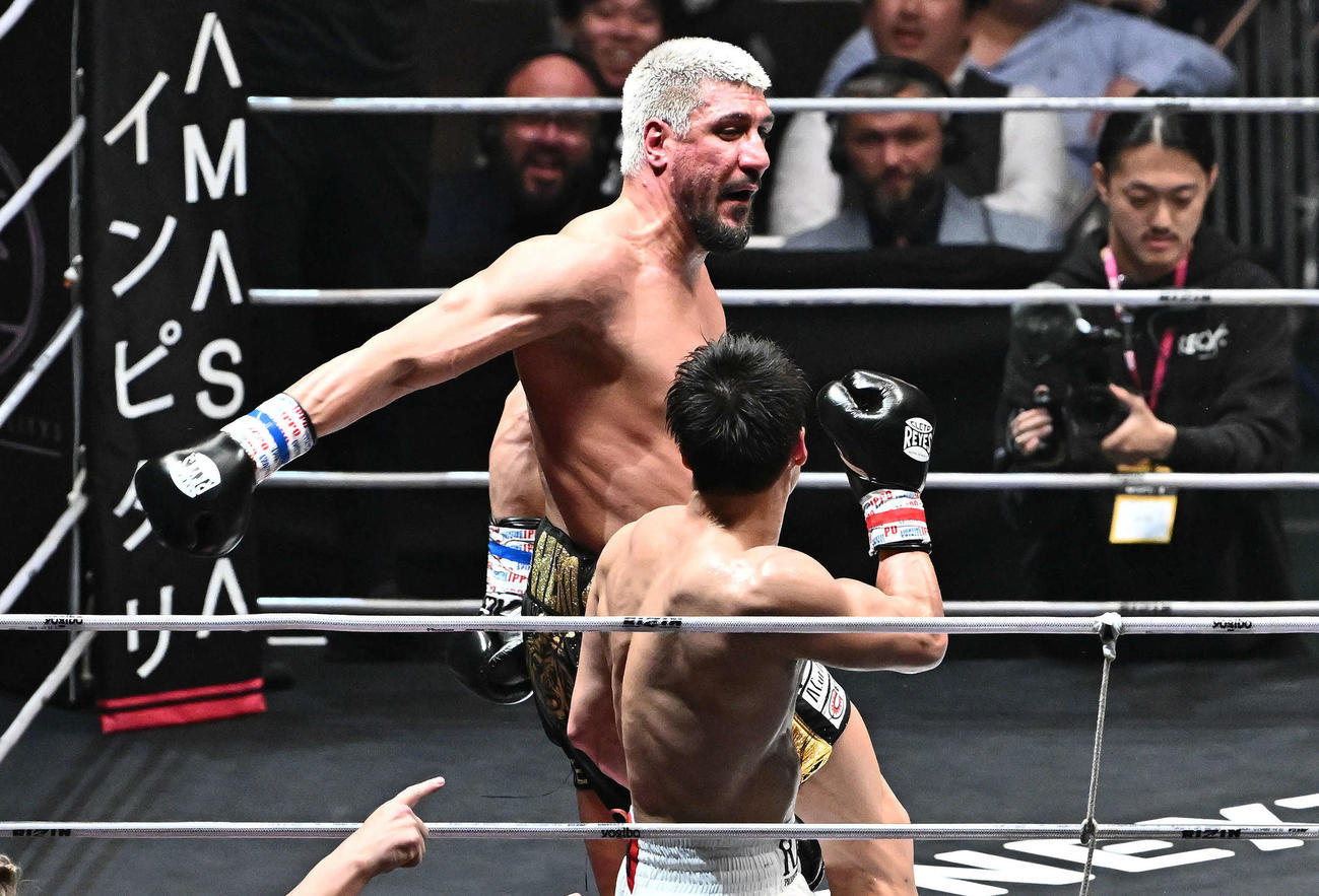 シナ・カリミアン（後方）は反則のバックハンドブローを安保瑠輝也に放つ（撮影・滝沢徹郎）