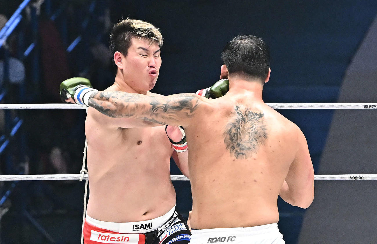 上田幹雄（左）はキム・テインにパンチを打ち込む（撮影・滝沢徹郎）