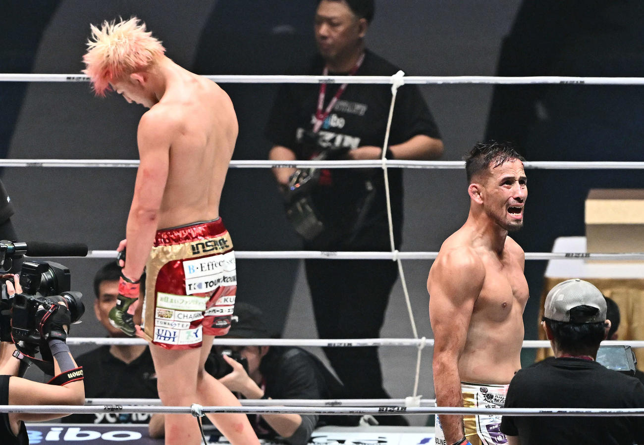 鈴木千裕（後方）に勝利し新チャンピオンとなったクレベル・コイケは雄たけびを上げる（撮影・滝沢徹郎）