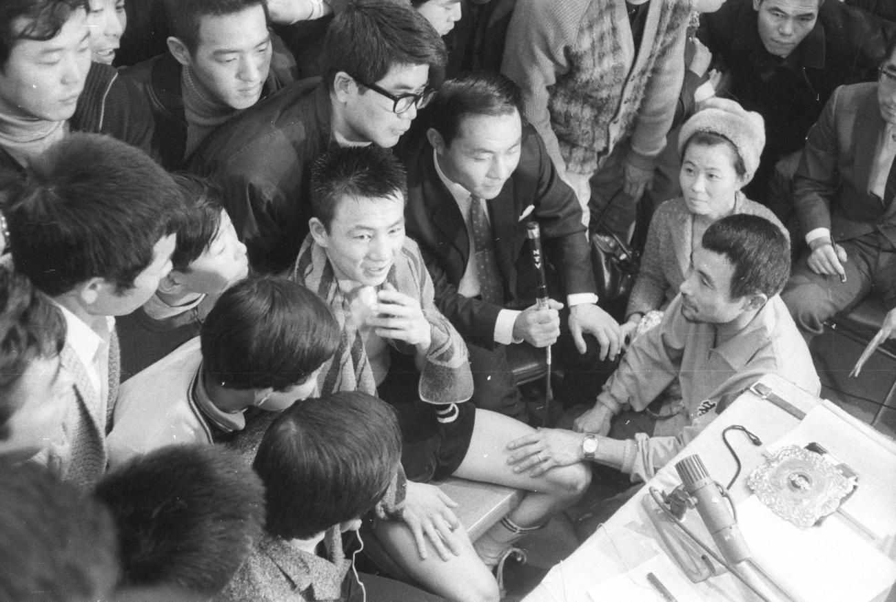 大場政夫にインタビューする日本テレビ本多当一郎アナ。右は長野ハル帝拳マネジャー、右手前は高田茂男トレーナー（1969年12月14日撮影）