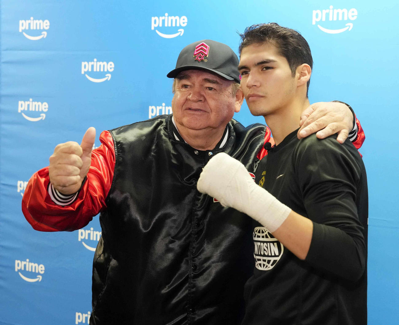 公開練習前にトレーナーのレイノソ氏（左）と記念撮影に臨むクエジャル（撮影・小沢裕）