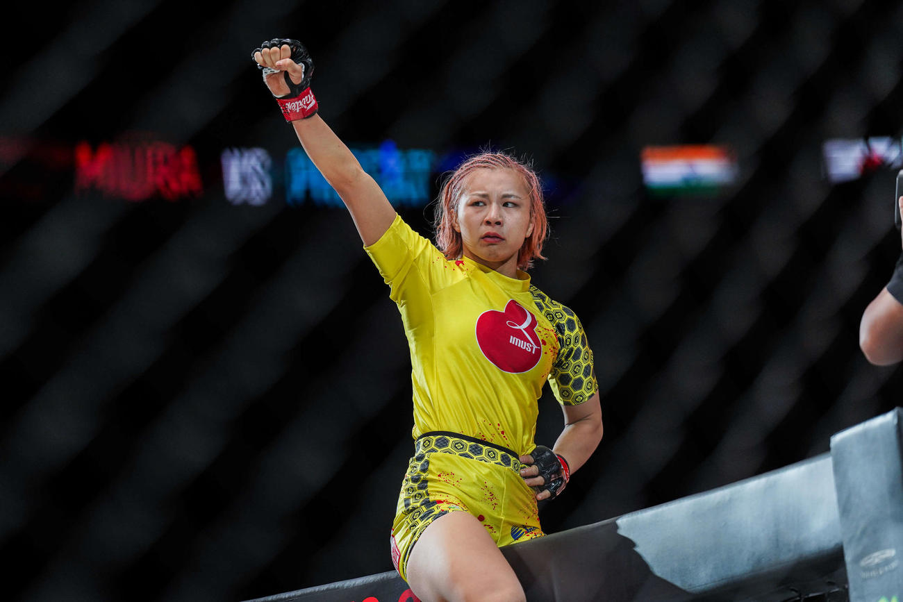 少し涙ぐみながら金網に登ってガッツポーズの三浦彩佳（C）ONE Championship