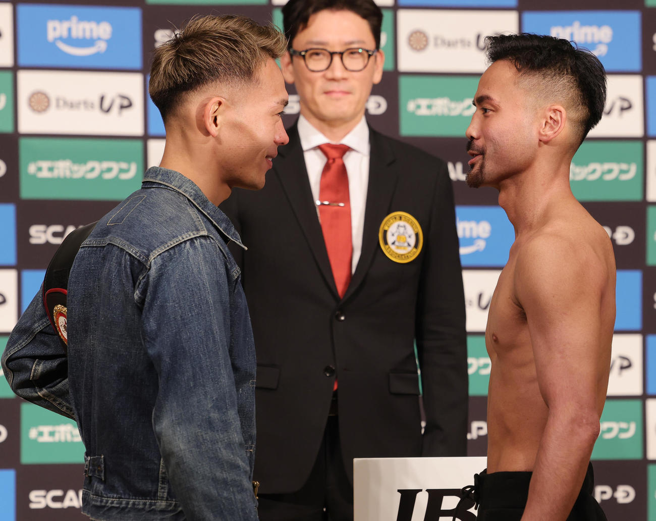 計量をクリアし笑顔でフェイスオフを行う、WBA世界バンタム級王者の堤（左）と挑戦者の比嘉（撮影・野上伸悟）