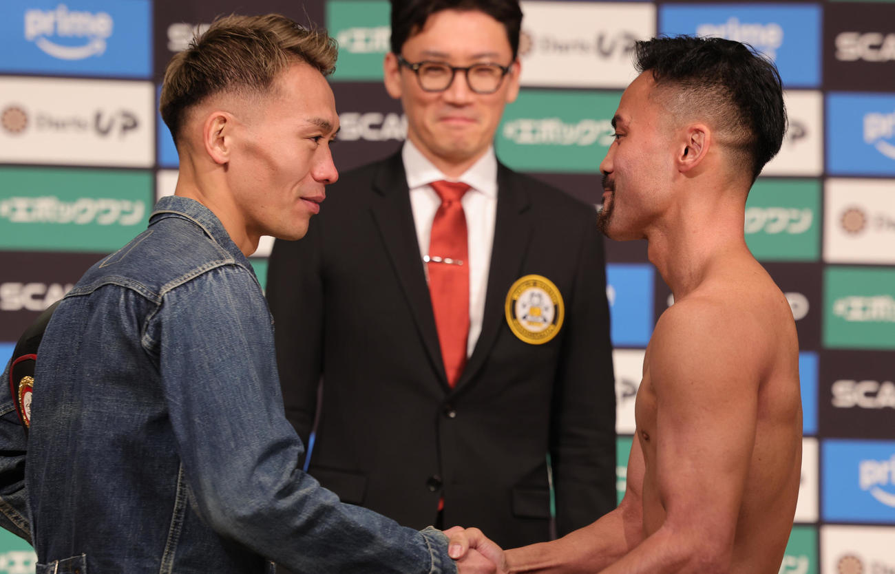 計量をクリアし握手する、WBA世界バンタム級王者の堤（左）と挑戦者の比嘉（撮影・野上伸悟）