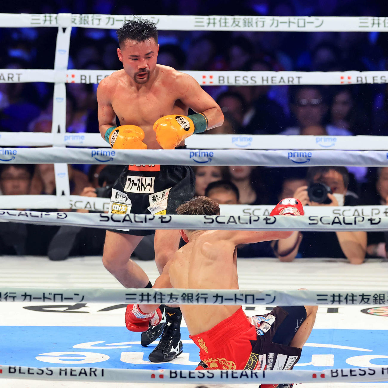 WBA世界バンタム級タイトルマッチ　9回　堤（手前）に強烈なパンチでダウンを奪う比嘉（撮影・浅見桂子）