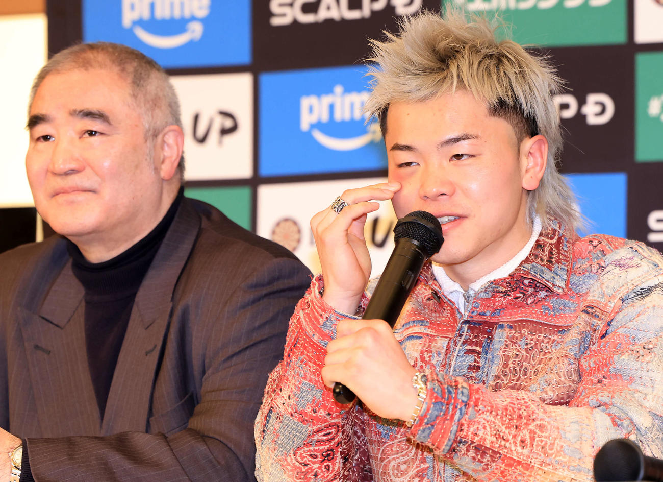 勝利から一夜明けの会見で、右目の下に出来たアザを触りながら質問に答える那須川（右）。左は浜田代表（撮影・浅見桂子）