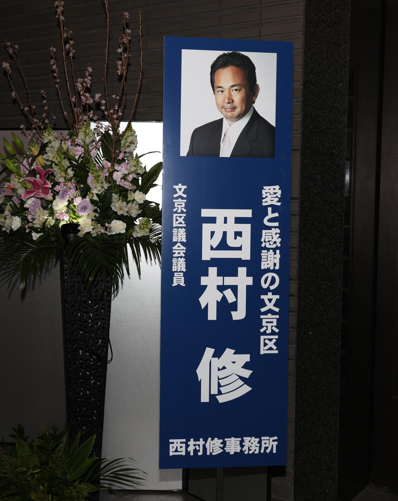通夜に飾られた西村修氏区議の立て看板（撮影・中島郁夫）