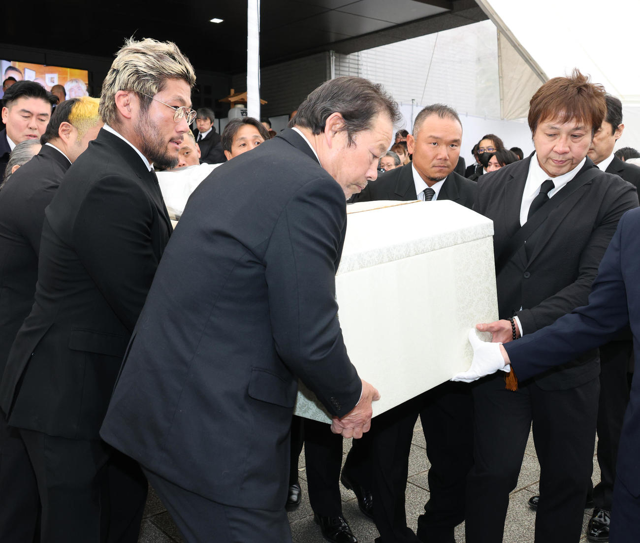 SANADA（左から3人目）、藤波辰爾（左から4人目）、土方隆司（左から5人目）、小島聡（右端）らレスラーたちによって運ばれる西村修氏の棺（撮影・中島郁夫）