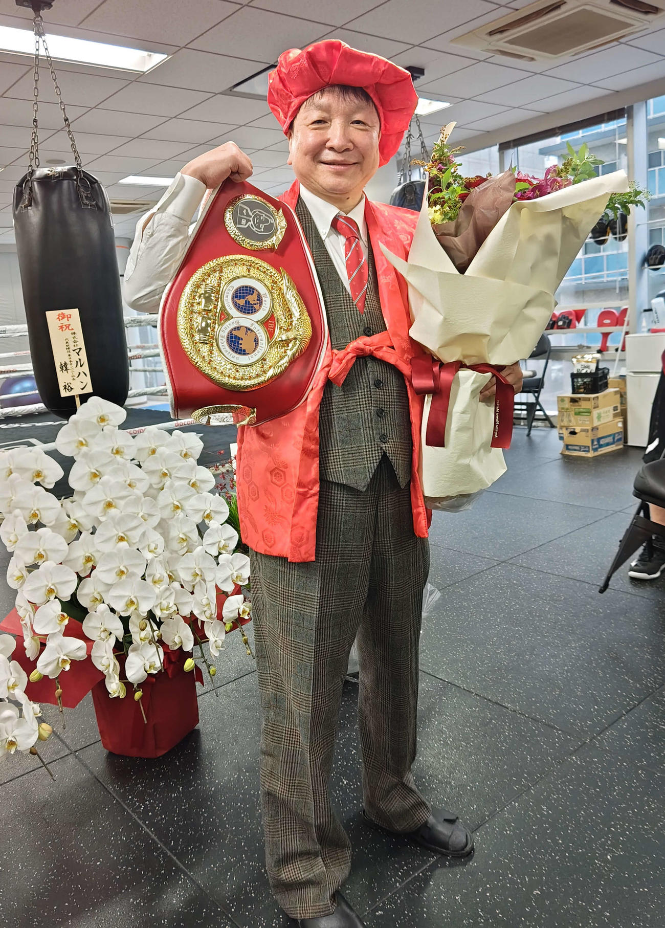 8日に還暦となる60歳の誕生日を迎え、特製の赤い還暦ベルト、ちゃんちゃんこと頭巾を着用した大橋ジム大橋秀行会長