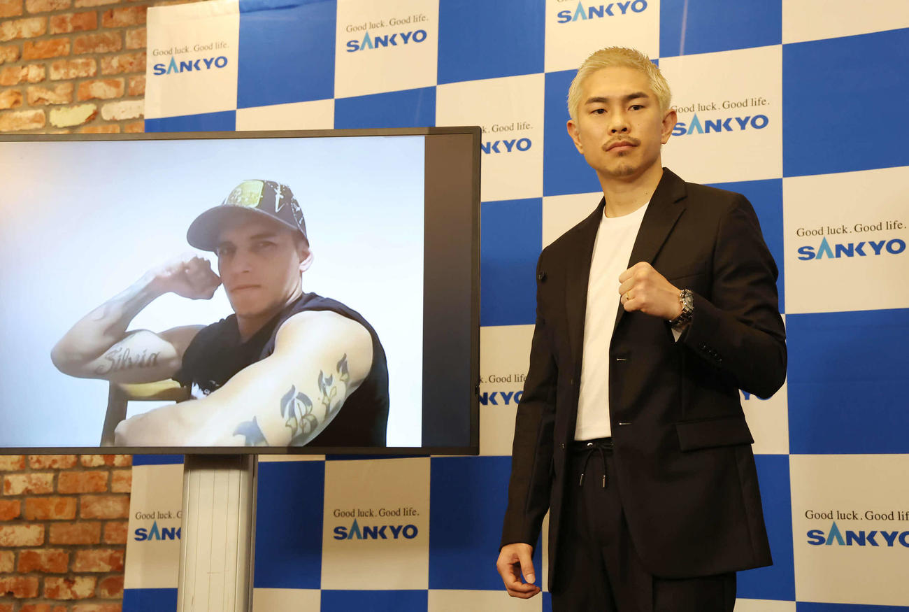 オンライン参加の王者マルティネスとカメラに向かってポーズを決める井岡（撮影・丹羽敏通）