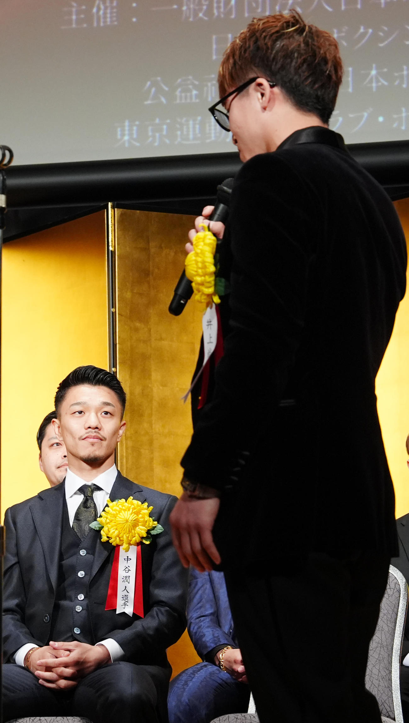 年間表彰式での壇上で、井上尚（右）から対戦を呼びかけられる中谷（撮影・江口和貴）